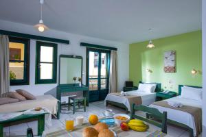 a room with two beds and a table with food on it at Golden Sun in Hersonissos