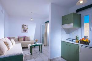 a kitchen and a living room with a couch at Golden Sun Holiday Apts by Estia in Hersonissos