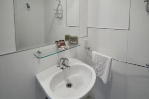uma casa de banho branca com um lavatório e um espelho em Aoraki Mount Cook Alpine Lodge em Mount Cook Village
