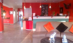 uma sala de estar com paredes vermelhas e um sofá e uma mesa em Whispering Palms Inn em Del Rio
