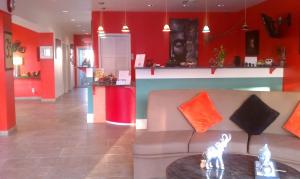 a living room with red walls and a couch and a table at Whispering Palms Inn in Del Rio