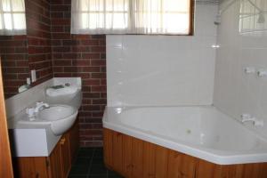 y baño con bañera blanca, lavamanos y bañera. en Aristocrat Waurnvale, en Geelong