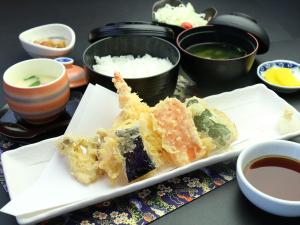 a plate of food with sushi on a table at Business Hotel Amakusa in Yanagi