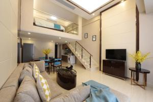 a living room with a couch and a tv at WAIFIDEN Duplex Hotel Apartment Zhongyong Jinyu Branch-Free shuttle bus during the Canton Fair in Guangzhou