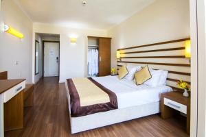 a hotel room with a large bed and a kitchen at Hotel Akbulut & Spa in Guzelcamlı