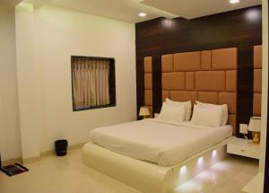 a bedroom with a large bed with a wooden headboard at Hotel Rezo's in Baga