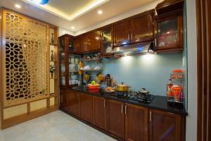a kitchen with wooden cabinets and a counter top at Hue Homestay Riverside in Hue
