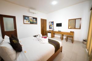 a hotel room with a bed and a desk at Anggie Stay in Kerobokan