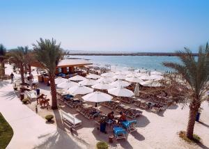 an overhead view of a beach with tables and white umbrellas at Yas Island Rotana Abu Dhabi in Abu Dhabi