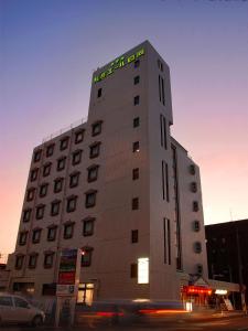 a building with a sign on the top of it at Hotel Rumieru Hyuga in Hyuga