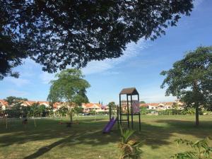 un parque infantil con un tobogán púrpura en un parque en The Secret Place en Melaka