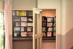 a room with two book shelves filled with books at Hotel Rumieru Hyuga in Hyuga