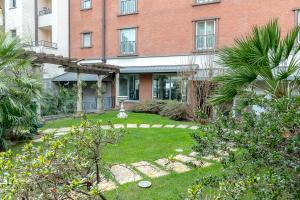 a garden in front of a brick building at Hotel Sunflower in Milan