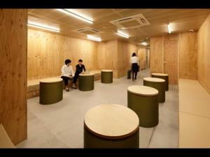 a group of people in a waiting room with stools at Do-c Shibuya Ebisu in Tokyo