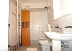 łazienka z 2 toaletami, umywalką i umywalką w obiekcie Apartament Castello Nago w orbole