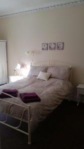 a bedroom with a large bed with purple towels on it at Blue Peter hotel in Stranraer
