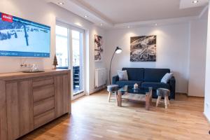 ein Wohnzimmer mit einem blauen Sofa und einem TV in der Unterkunft Appartement Central in Kitzbühel