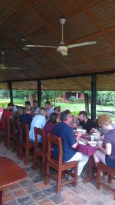 a group of people sitting at tables eating food at Big Foot Safari Lodge in Wli Afegame