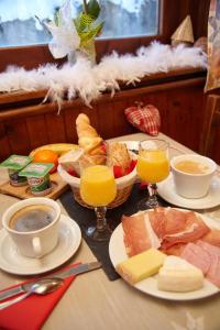 a table topped with plates of food and glasses of orange juice at La Gelinotte in Les Contamines-Montjoie