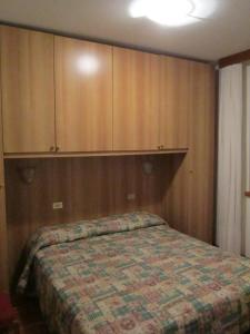 モルヴェーノにあるCasa Cristinaのベッドルーム(ベッド1台、木製キャビネット付)