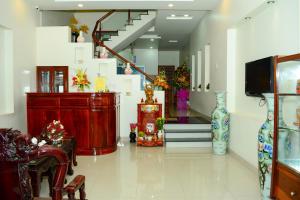 a living room with a staircase and vases on the floor at Truong Ca Hotel in Phan Thiet