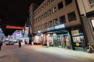 a street at night with people walking in front of buildings at Forenom Hostel Jyväskylä in Jyväskylä