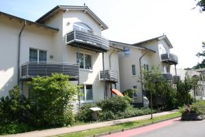 an apartment building with balconies on a street at Appartment Strandduene in Binz