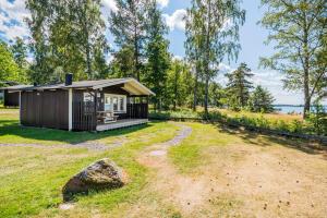 uma pequena cabana num campo com uma rocha em First Camp Ekudden-Mariestad em Mariestad