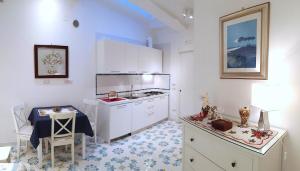 ナポリにあるMini Appartamento Al Chiostroの青と白のフロアのキッチン(白いキャビネット付)