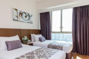 ein Hotelzimmer mit 2 Betten und einem Fenster in der Unterkunft Somerset Vista Ho Chi Minh City in Ho-Chi-Minh-Stadt