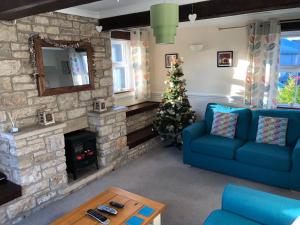 a living room with a christmas tree and a blue couch at The Annexe in Timsbury