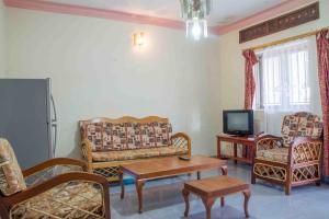 un soggiorno con divani, TV e tavolo di Hotel Nok Continental a Gulu