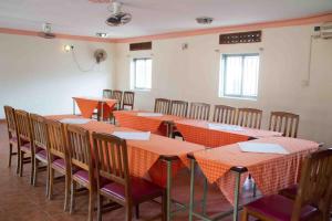 una habitación con mesas naranjas y sillas. en Hotel Nok Continental, en Gulu