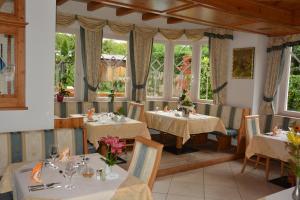 un restaurante con mesas, sillas y ventanas en Hotel Tanja-Sonnenhof en Laces