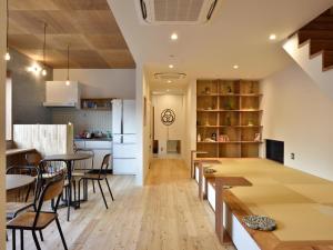 a kitchen and dining room with tables and chairs at Hostel Mitsuwaya Osaka in Osaka