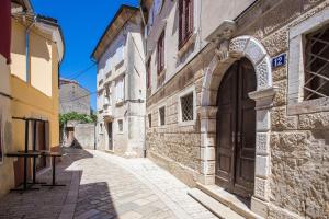 an alley in an old town with a large door at Old Town apartment in Poreč