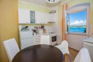 une cuisine avec une table et des chaises et une fenêtre dans l'établissement Old Town apartment, à Poreč