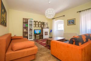 a living room with two orange couches and a tv at Old Town apartment in Poreč