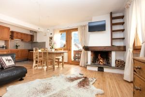 a living room with a fireplace and a table at Casa Melide 2 in Bormio
