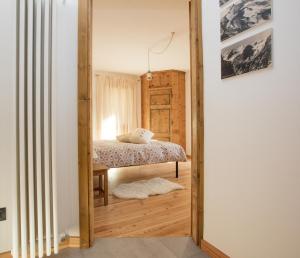 a bedroom with a bed and a wooden floor at Casa Melide 2 in Bormio