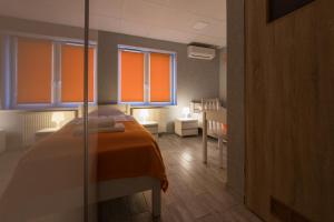 ein Schlafzimmer mit einem Bett mit einer orangefarbenen Decke in der Unterkunft Dom Sportowca in Ratibor