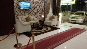 a living room with two chairs and a tv at المهيدب 1 للشقق المخدومة - اقتصادى in Buraydah