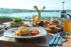 a table topped with plates of food and drinks at Schulphoek Seafront Boutique Hotel in Hermanus