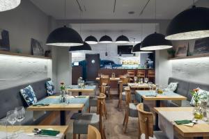 a restaurant with tables and chairs and pendant lights at Villa Zagórze in Rumia