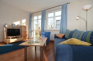 オストゼーバート・ゼリンにあるVilla Seerose - Appartement 01のリビングルーム(青いソファ、テーブル付)