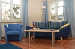 ein Wohnzimmer mit einem blauen Sofa und einem Tisch in der Unterkunft Villa Seerose - Appartement 01 in Ostseebad Sellin