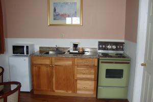 a kitchen with a sink and a stove at Royal Napanee Inn in Napanee