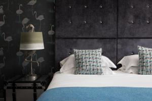 a bedroom with a bed with blue and white pillows at The Florentine in Sheffield