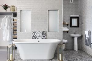 a bathroom with a white tub and two mirrors at The Florentine in Sheffield +28 photos