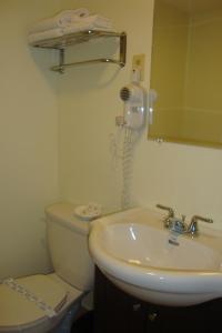 La salle de bains est pourvue de toilettes, d'un lavabo et d'un téléphone. dans l'établissement Royal Napanee Inn, à Napanee